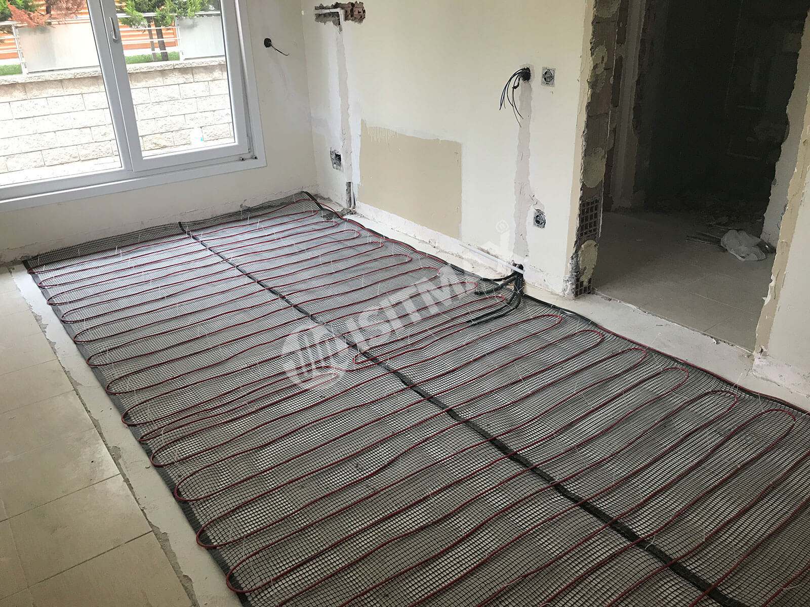 Zemine montaj aparatlarıyla sabitlenmiş elektrikli yerden ısıtma kablosunun serim düzeni